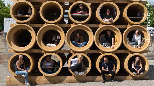 Installationskünstler Hiwa K. (unten, 2.v.r.) sitzt am 10.06.2017 bei der Eröffnung der documenta 14 in Kassel (Hessen) in einer Röhre seines Kunstwerks "When We Were Exhaling Images