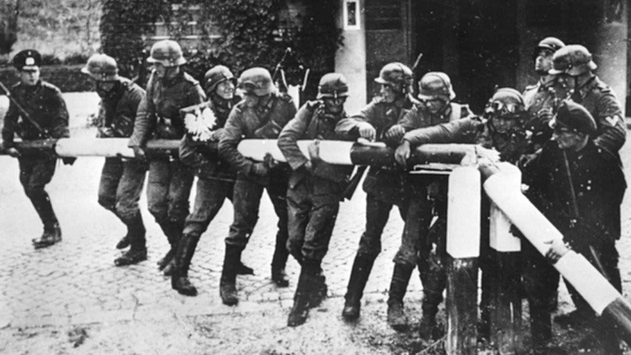 Soldaten der deutschen Wehrmacht reißen am 1. September 1939 einen rot-weißen Schlagbaum an der polnischen Grenze nieder: Der Beginn des Zweiten Weltkriegs und der deutschen Schreckensherrschaft in Polen. Soldaten der deutschen Wehrmacht reißen am 1. September 1939 einen rot-weißen Schlagbaum an der polnischen Grenze nieder: Der Beginn des Zweiten Weltkriegs und der deutschen Schreckensherrschaft in Polen.