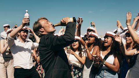 Der Schauspieler Mads Mikkelsen in einem Szenenfoto von Thomas Vinterbergs Film "Der Rausch". Mikkelsen trinkt aus einer Bierflasche.
