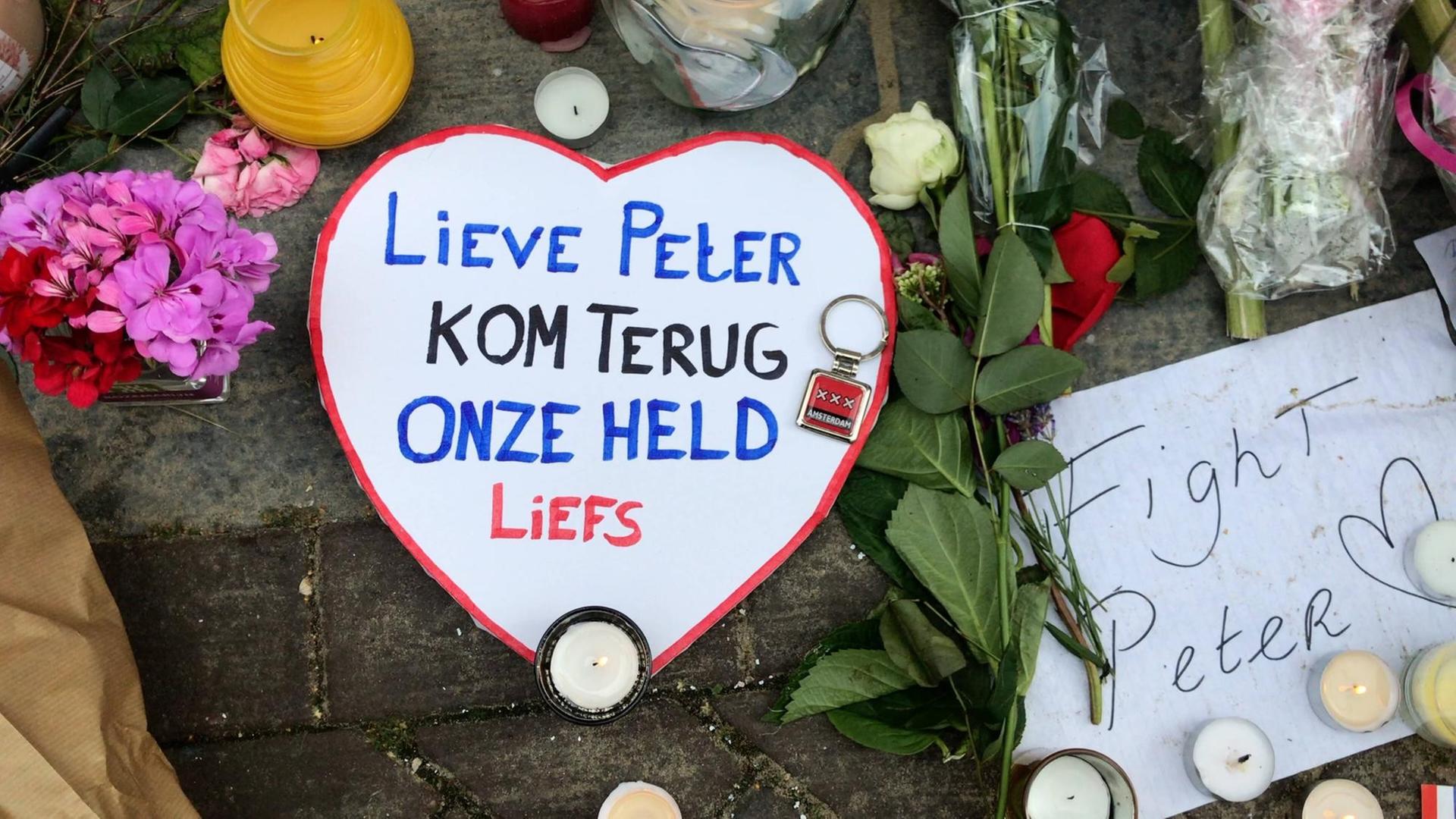 Auf einem Pappherz neben Blumen am Tatort des Anschlags auf Peter de Vries steht: "Lieber Peter, komm zurück, unser Held, Liebling". Auf einem Pappherz neben Blumen am Tatort des Anschlags auf Peter de Vries steht: "Lieber Peter, komm zurück, unser Held, Liebling".