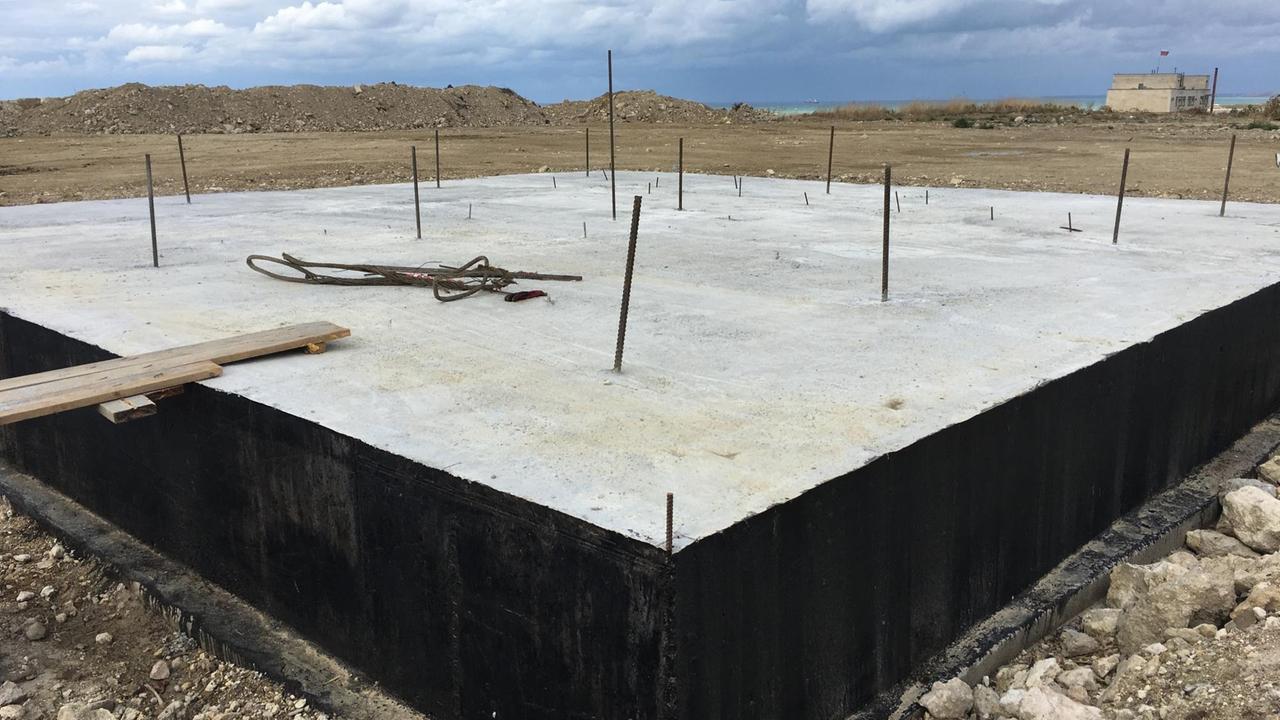 Großer Betonsockel mit Metall-Stäben, die herausragen. Großer Betonsockel mit Metall-Stäben, die herausragen.