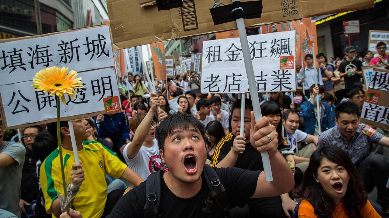 Protestierende rufen Slogans und halten Plakate hoch bei einer Demonstration gegen Job-Kürzungen und schlechte Lebensbedingungen am 1. Mai 2014 in Macau. Protestierende rufen Slogans und halten Plakate hoch bei einer Demonstration gegen Job-Kürzungen und schlechte Lebensbedingungen am 1. Mai 2014 in Macau.