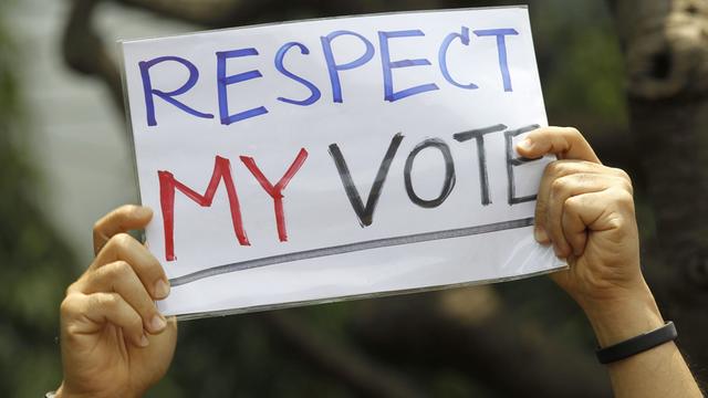 Zwei Hände halten ein Schild mit der Aufschrift "Respect my vote" hoch.