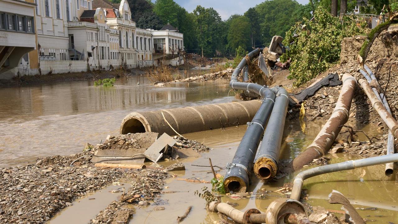 Weggeschwemmte Versorgungsleitungen liegen am Ufer der Ahr gegenüber dem Kurhaus. Die Flut hat im Ahrtal große Teile der Infrastruktur zerstört. Zweieinhalb Wochen nach der Hochwasserkatastrophe laufen die Aufräumarbeiten auf Hochtouren. Weggeschwemmte Versorgungsleitungen liegen am Ufer der Ahr gegenüber dem Kurhaus. Die Flut hat im Ahrtal große Teile der Infrastruktur zerstört. Zweieinhalb Wochen nach der Hochwasserkatastrophe laufen die Aufräumarbeiten auf Hochtouren.