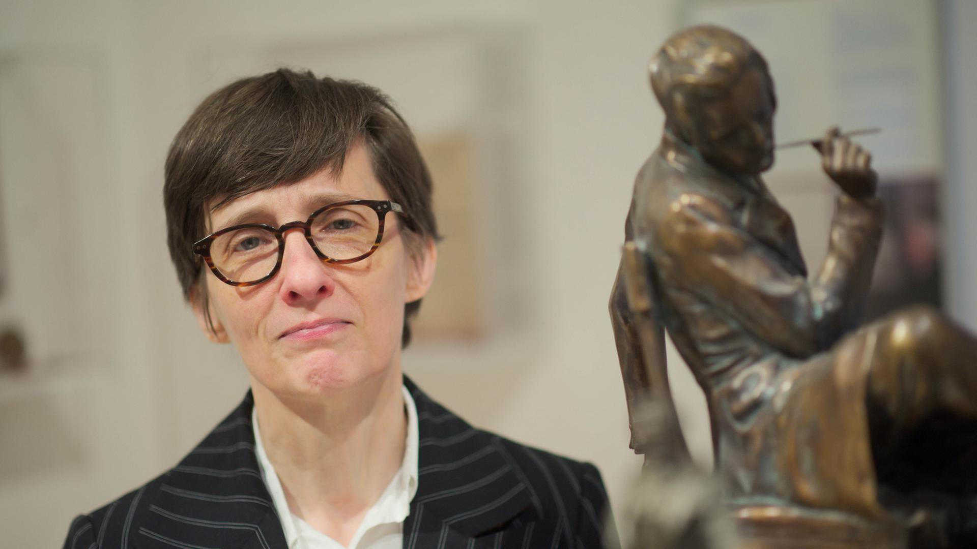 Die Autorin Alison Louise Kennedy steht am 09.12.2016 bei einem Pressegespräch in Düsseldorf (Nordrhein-Westfalen) neben Figuren, die den Schriftsteller Heinrich Heine darstellen.