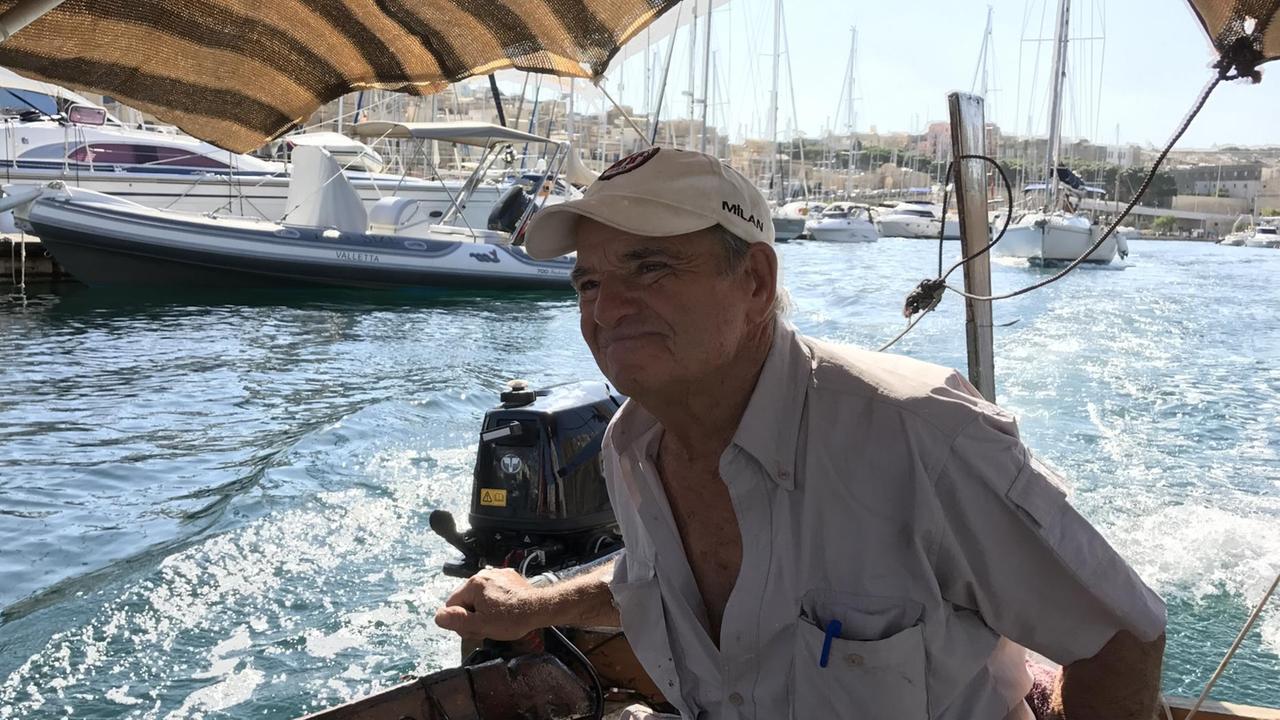 Maltesischer Fischer Alfredo Micaleff - sitzt gebräunt mit Hemd im Motorboot.