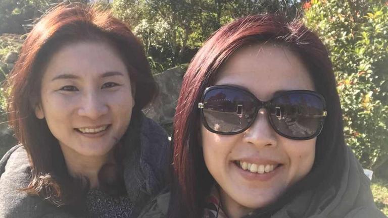 Su und Charlie werden von der Sonne angestrahlt und lächeln in die Kamera bei einem Selfie. Su und Charlie werden von der Sonne angestrahlt und lächeln in die Kamera bei einem Selfie.