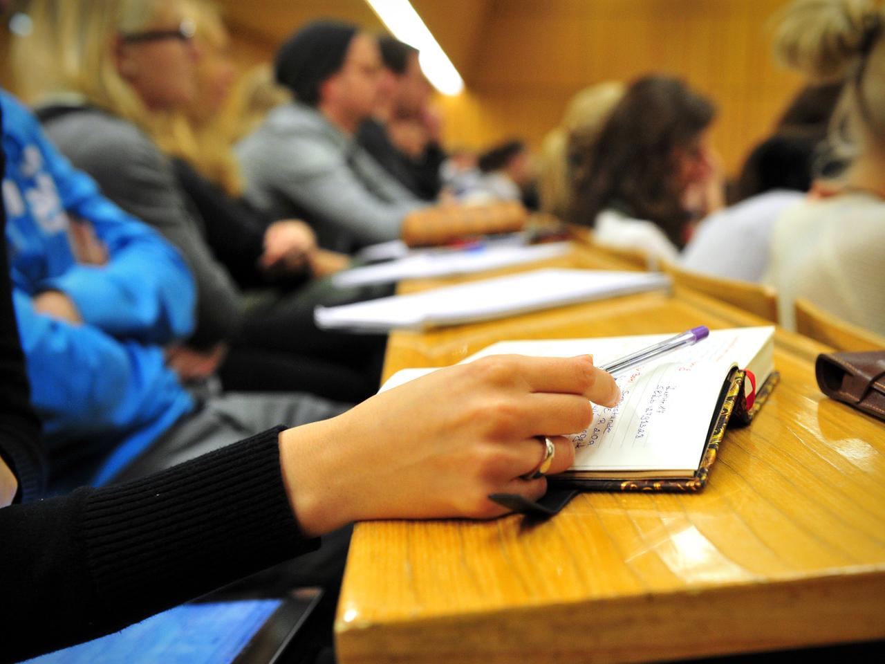 Eine Studentin der Schulpädagogik schreibt am 17.10.2012 während einer Vorlesung in einem vollen Hörsaal in der Universität in Tübingen (Baden-Württemberg) mit.