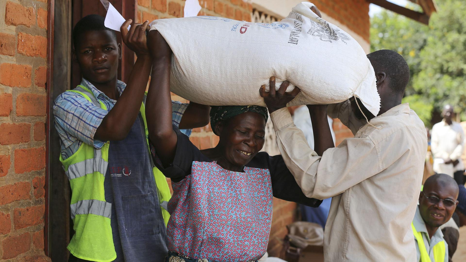 Menschen erhalten am 15.3.2016 an einem Verteilungspunkt des UN World Food Programme nordwestlich von Lilongwe, Malawi, Lebensmittelhilfe.