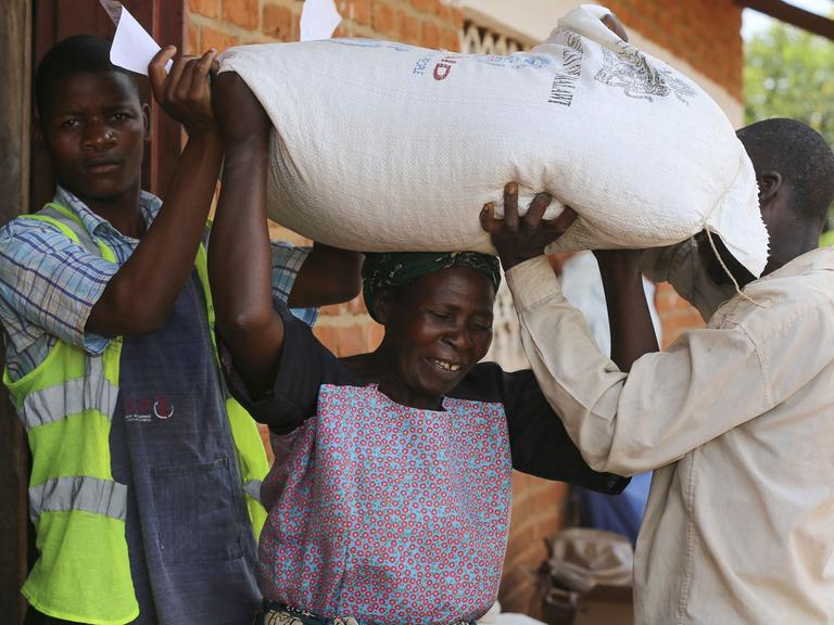 Menschen erhalten am 15.3.2016 an einem Verteilungspunkt des UN World Food Programme nordwestlich von Lilongwe, Malawi, Lebensmittelhilfe.