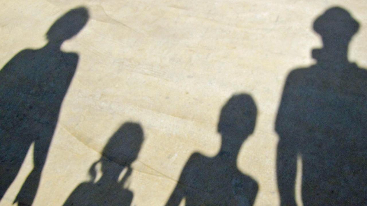 Der Schatten einer Familie, die sich an der Hand hält. Der Schatten einer Familie, die sich an der Hand hält.