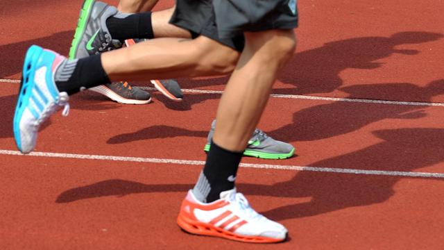 Die Schuhe/Füße von Hochleistungssportlern auf einer Laufbahn