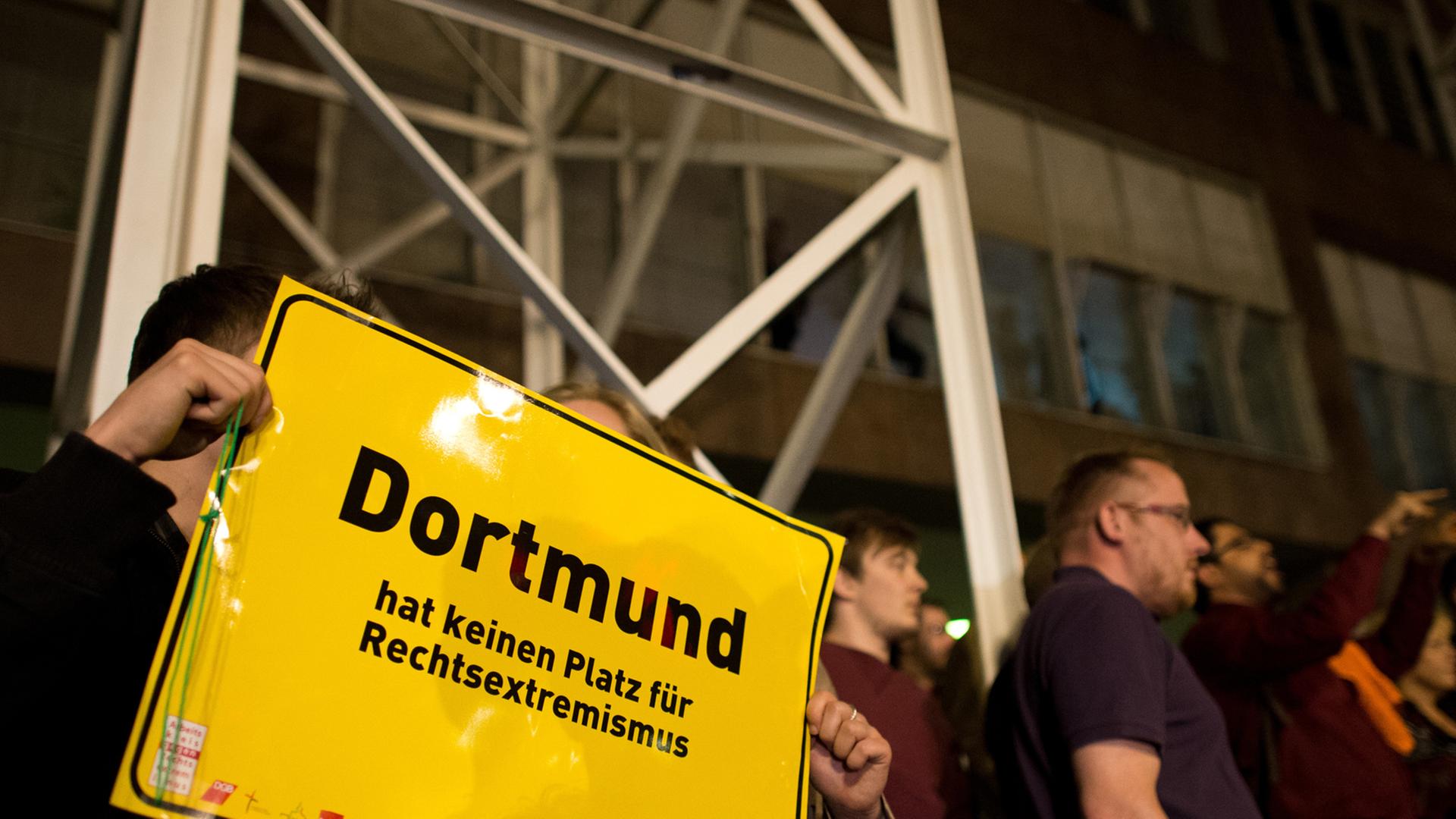 Ein Mann und eine Frau zeigen am 25.05.2014 vor dem Rathaus in Dortmund (Nordrhein-Westfalen) ein Schild mit der Aufschrift "Dortmund hat keinen Platz für Rechtsextremismus". Eine Gruppe von Männern aus dem rechten Umfeld hatten versucht, das Rathaus am Wahlabend zu stürmen, wurde daran aber von Bürgern gehindert. Ein Mann und eine Frau zeigen am 25.05.2014 vor dem Rathaus in Dortmund (Nordrhein-Westfalen) ein Schild mit der Aufschrift "Dortmund hat keinen Platz für Rechtsextremismus". Eine Gruppe von Männern aus dem rechten Umfeld hatten versucht, das Rathaus am Wahlabend zu stürmen, wurde daran aber von Bürgern gehindert.