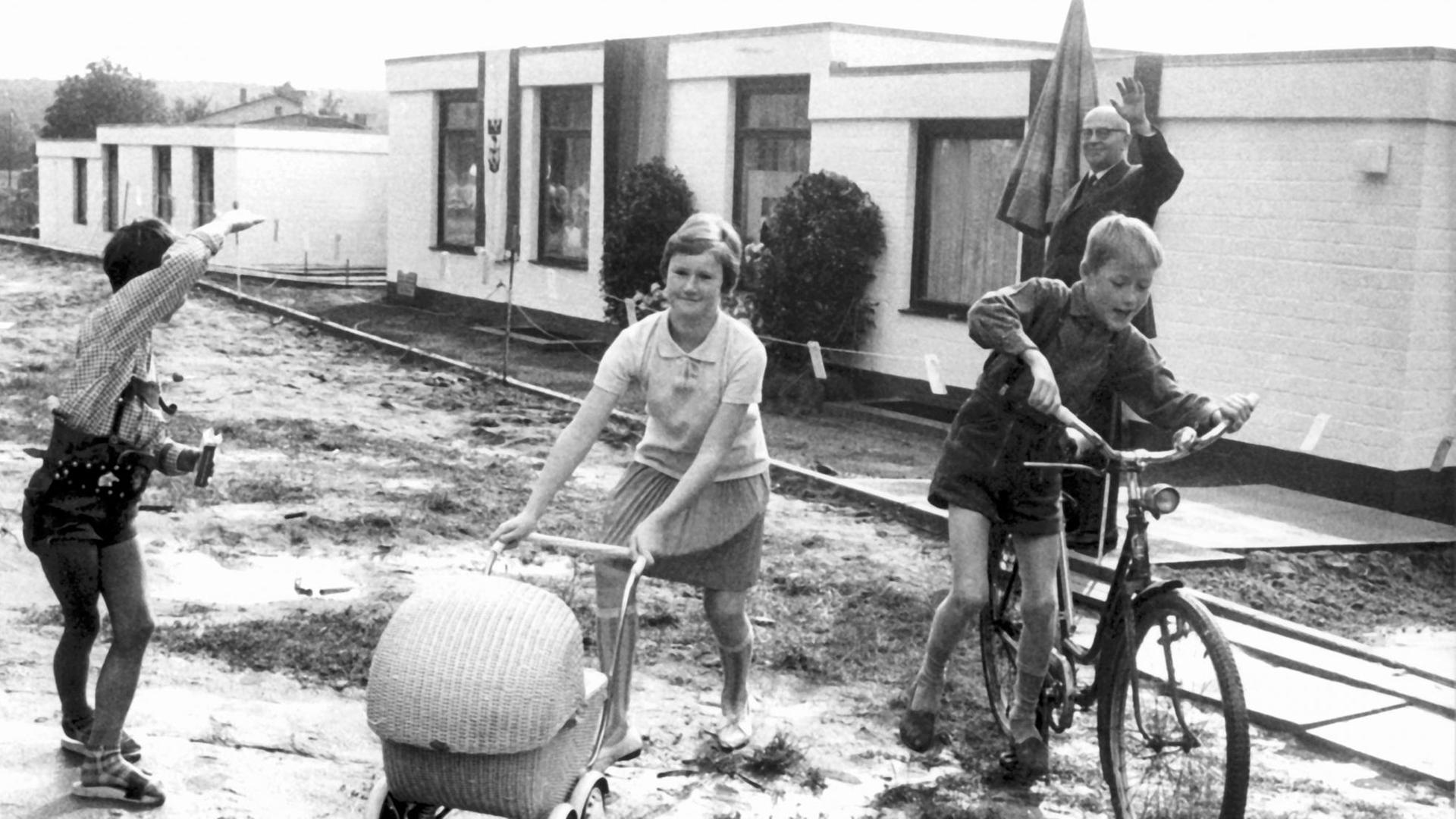 Zwei Jungen und ein Mädchen spielen am 11. September 1965 vor dem ersten im Bungalow-Stil gebauten Haus im Albert-Schweitzer-Kinderdorf in Berlin-Gatow e . Fünf Eine Woche nach dem Tod des berühmten Namensgebers wurde der Bungalow an die künftige Familienmutter übergeben. Sie und ihr Mann werden hier mit acht Waisenkindern im Alter von zwei bis zwölf Jahren eine Familie bilden.