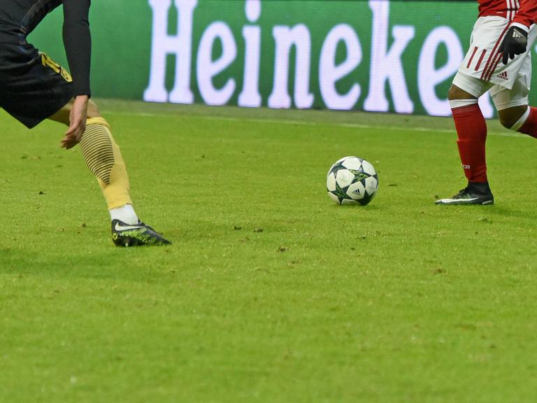 Zweikampf vor einer Heineken-Bierwerbung am Spielfeldrand