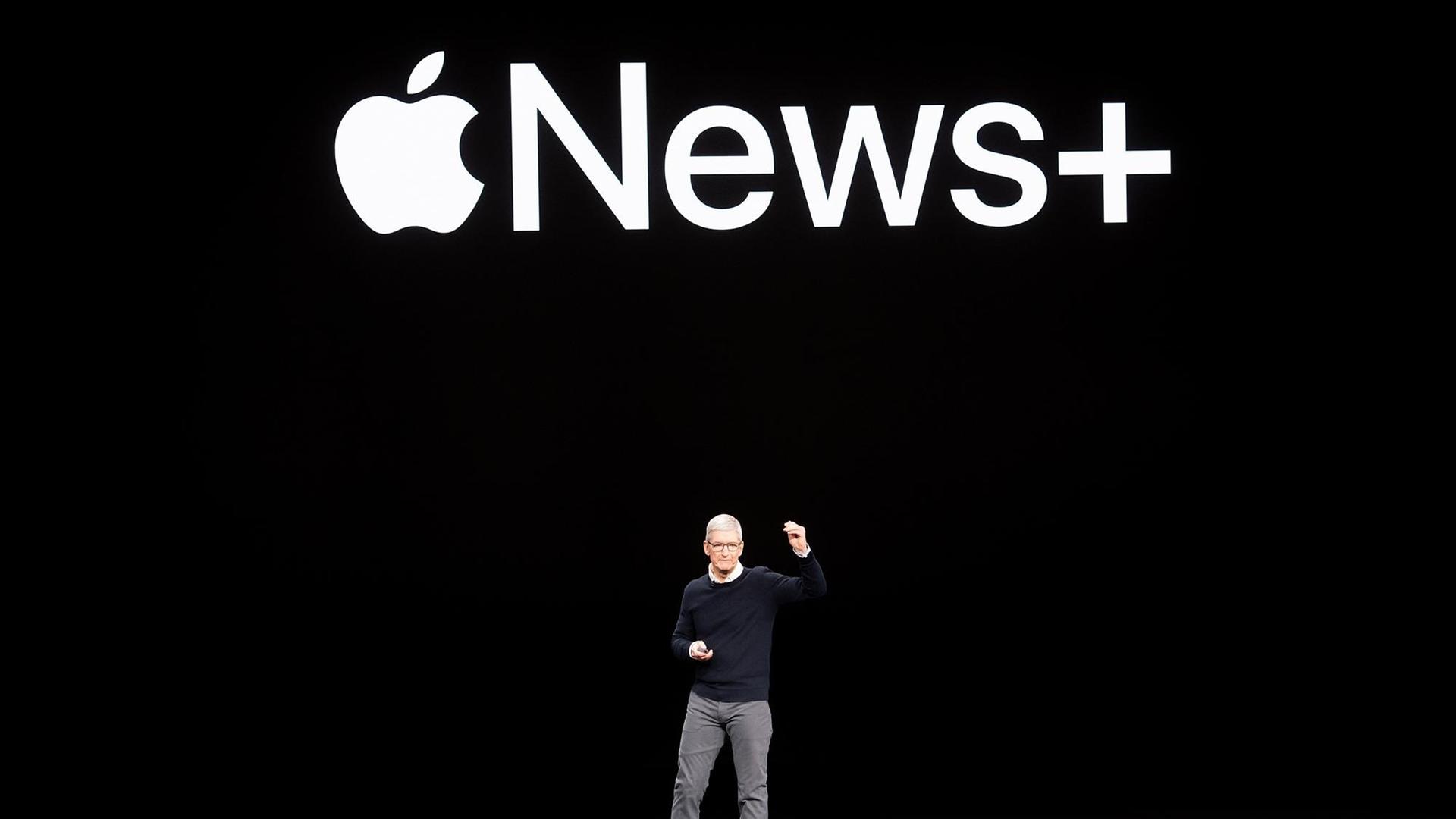 Der Chef des Technologieunternehmens Apple, Tim Cook, steht auf der Bühne. Auf der schwarzen Wand hinter ihm ist das Logo von Apple News Plus zu sehen. Der Chef des Technologieunternehmens Apple, Tim Cook, steht auf der Bühne. Auf der schwarzen Wand hinter ihm ist das Logo von Apple News Plus zu sehen.