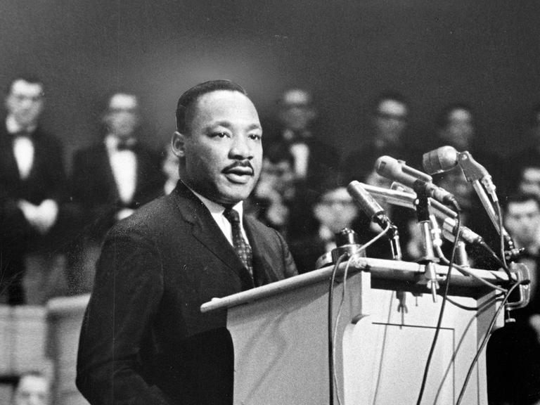 Martin Luther King steht an einem Rednerpult.