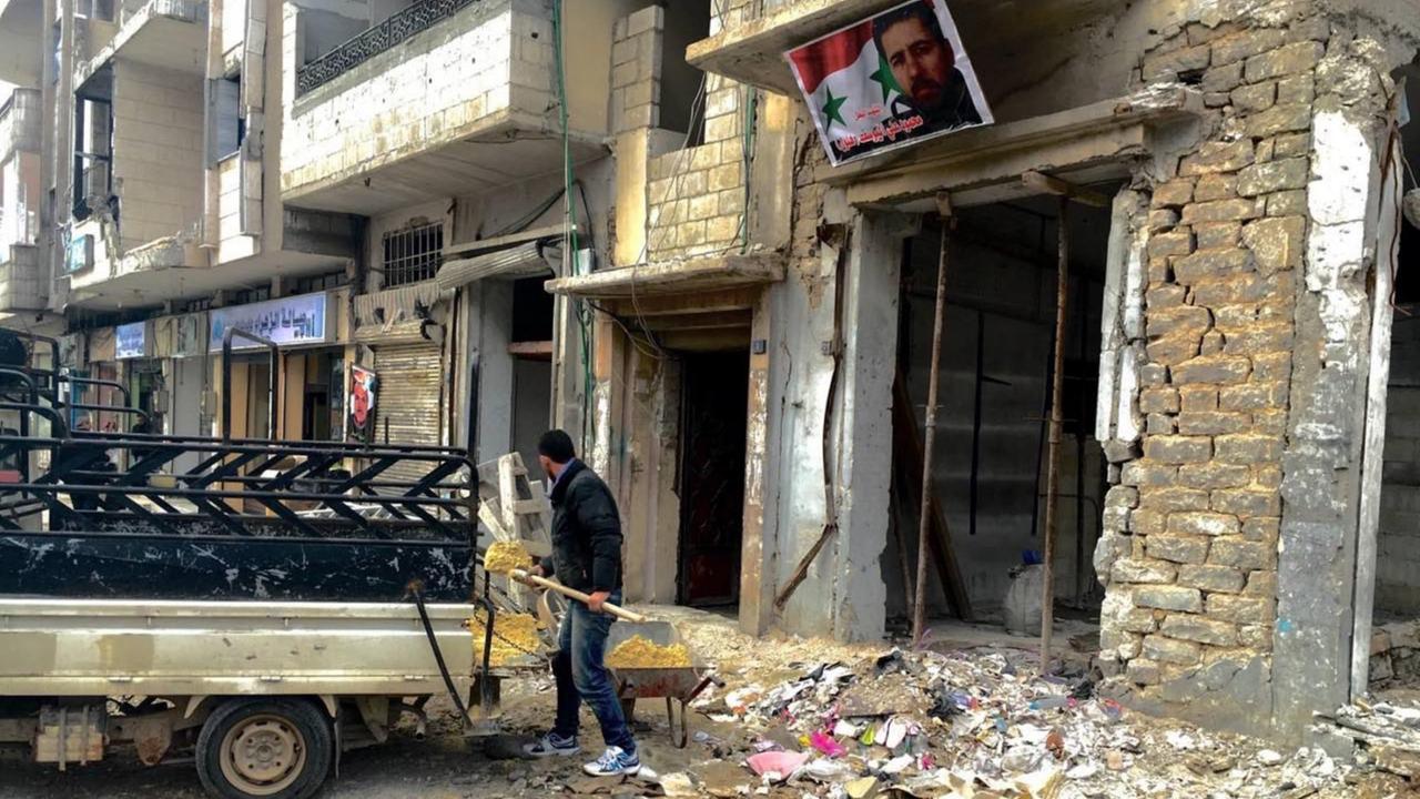 Anwohner in der syrischen Stadt Homs räumen nach einem Anschlag Trümmer weg.