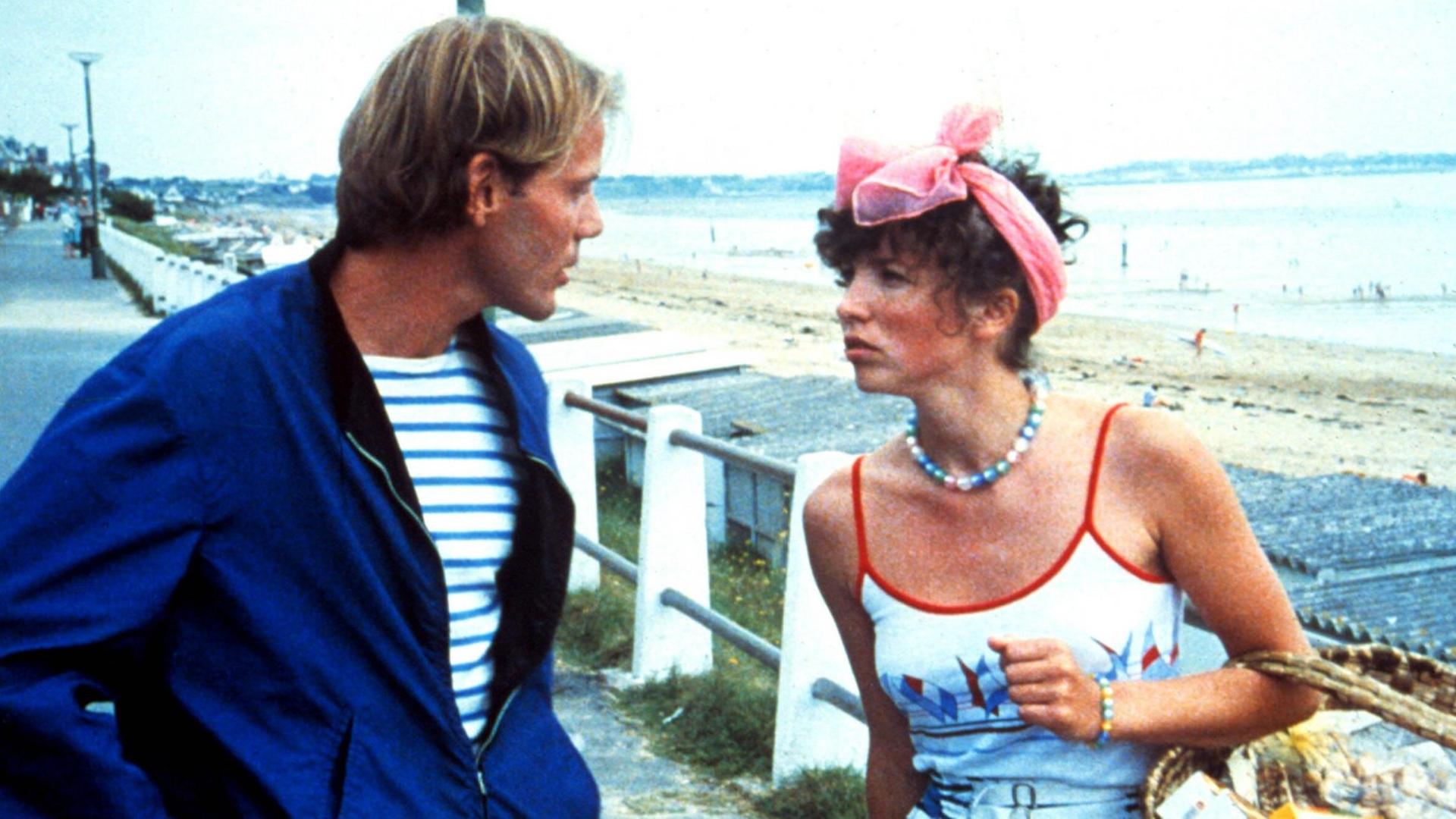 Ein Mann und eine Frau unterhalten sich auf einer Strandpromenade Ein Mann und eine Frau unterhalten sich auf einer Strandpromenade