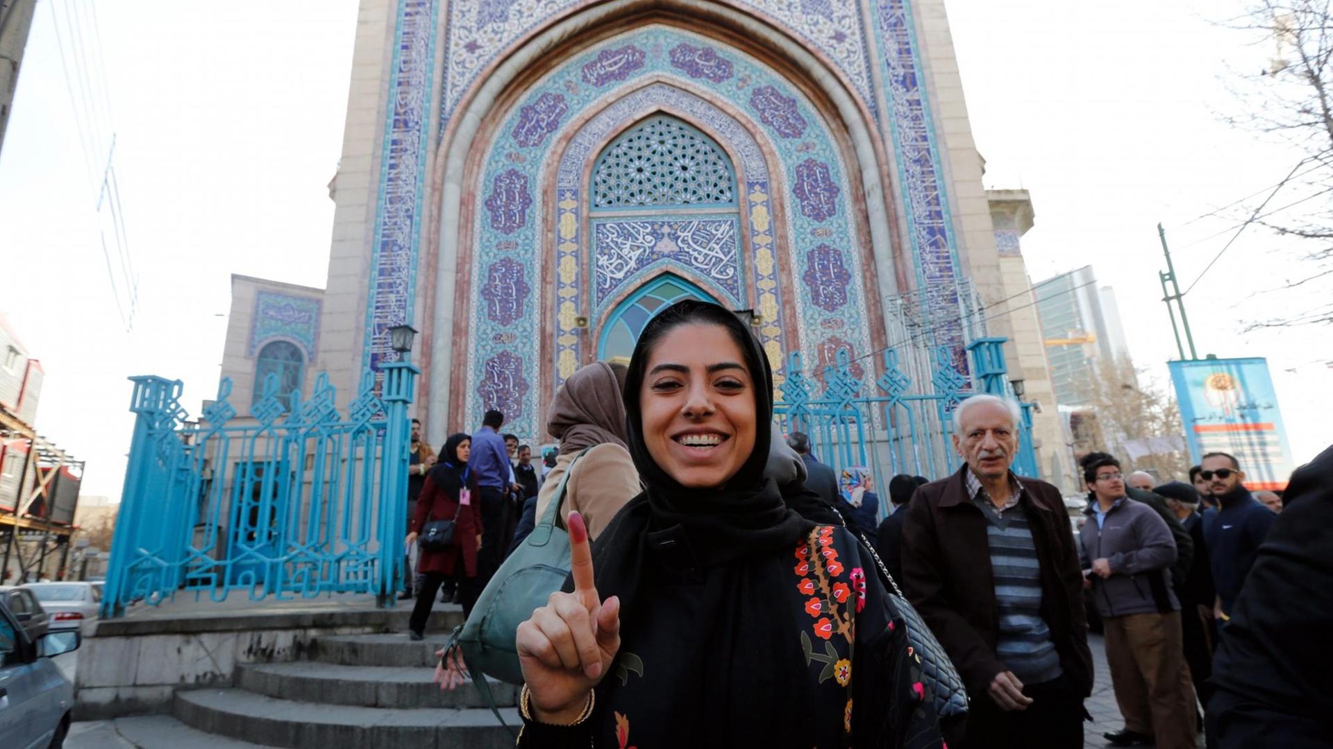 Eine junge Iranerin zeigt lächelnd ihren markierten Zeigefinger, nachdem sie ihre Stimme bei der Parlamentswahl in Teheran abgegeben hat. Eine junge Iranerin zeigt lächelnd ihren markierten Zeigefinger, nachdem sie ihre Stimme bei der Parlamentswahl in Teheran abgegeben hat.