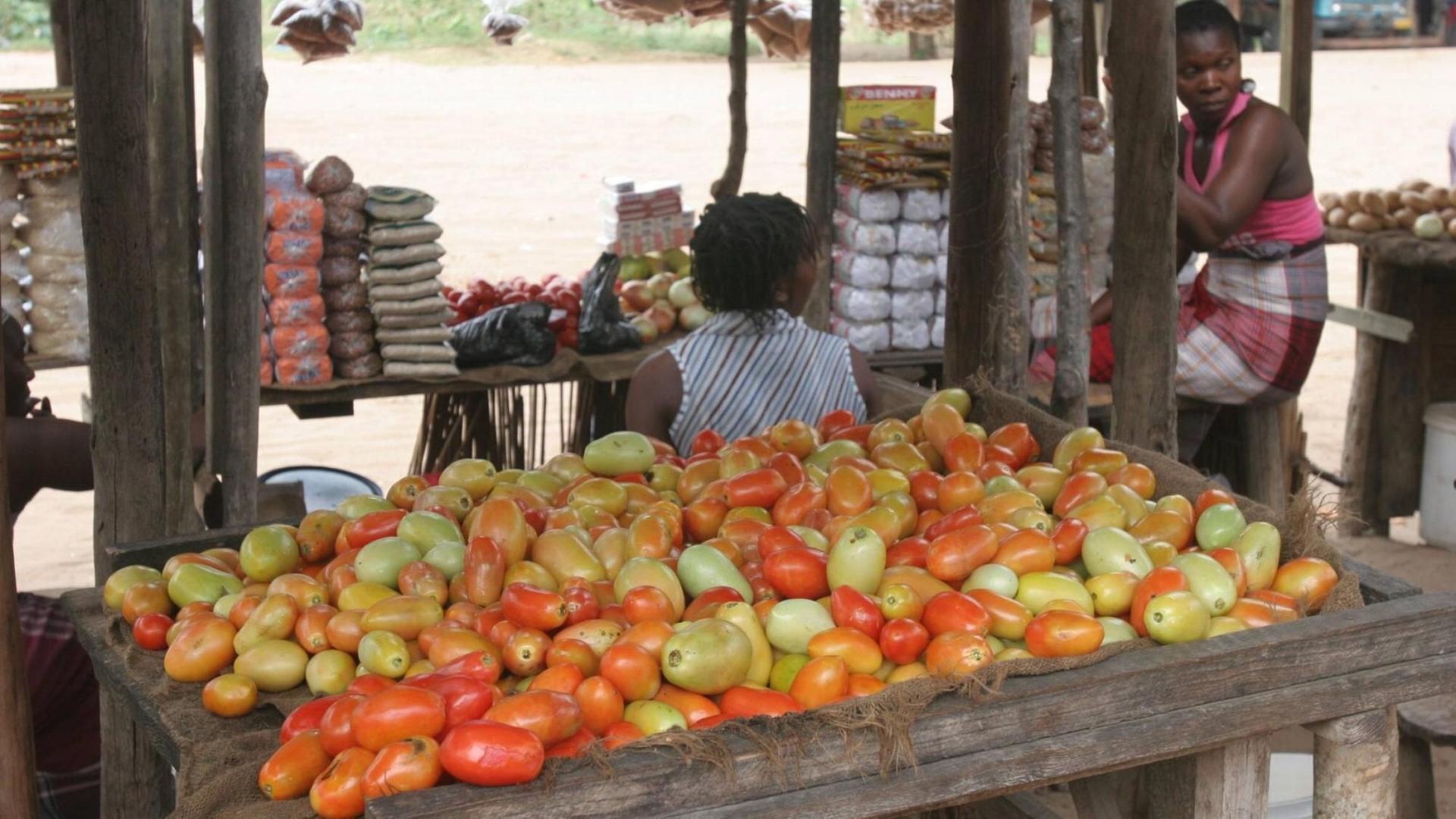 Frauen verkaufen auf einem Markt in Mosambik Gemüse.