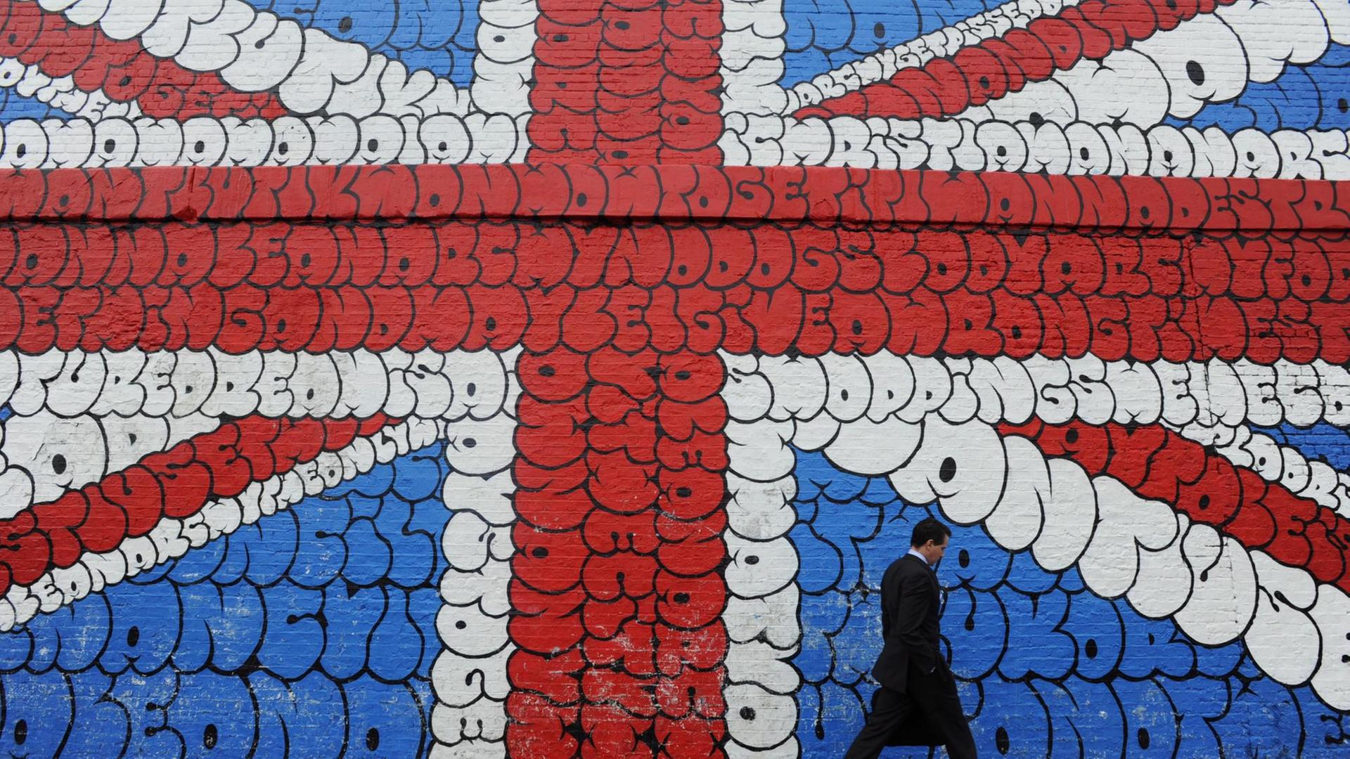 Der Union Jack als Graffito in London - ein Mann geht vor dem Wandgemälde entlang