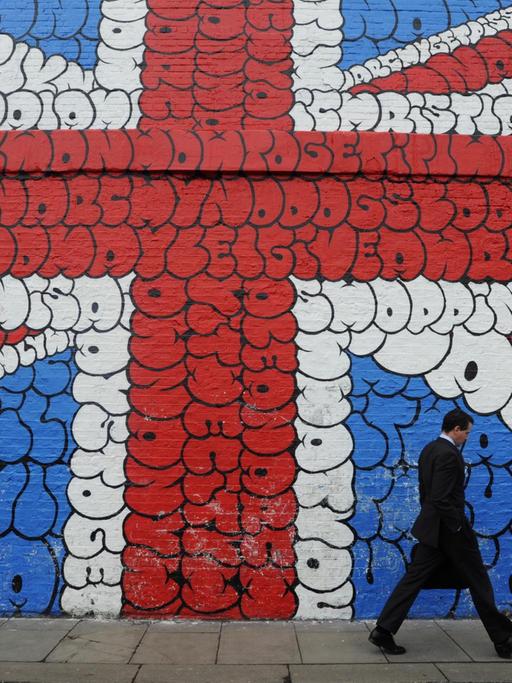 epa03105488 A man walks by a giant graffiti mural depicting the Union Jack in London, Britain, on 14 February 2012. Credit ratings agency Moody's has issued official notice to Britain and the Bank of England that their AAA credit ratings are at risk of a potential downgrade. EPA/FACUNDO ARRIZABALAGA |