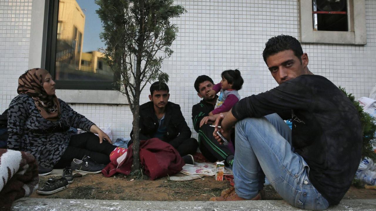 Flüchtlinge warten an einer Bushaltestelle in Istanbul.
