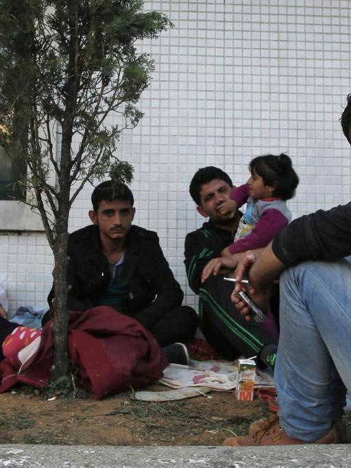 Flüchtlinge warten an einer Bushaltestelle in Istanbul.