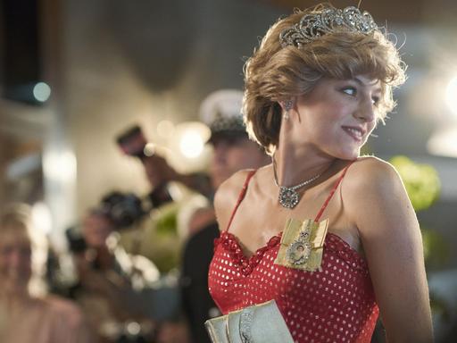 Szene aus "The Crown" Staffel 4, Diana Princess of Wales gespielt von Emma Corrin im Blitzlichtgewitter.