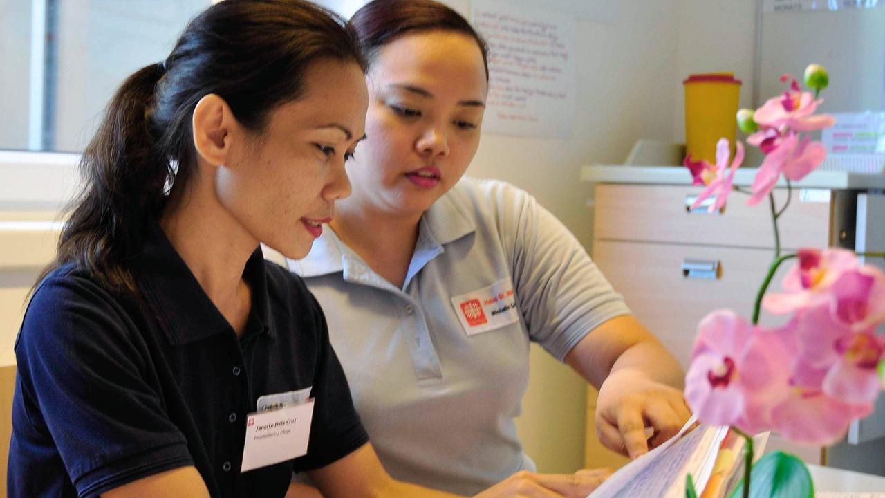 Pflegerin Janette Dela Cruz (l.) von den Philippinen wird im Caritas Altenheim St. Nikolaus in München von einer Kollegin eingewiesen. Pflegerin Janette Dela Cruz (l.) von den Philippinen wird im Caritas Altenheim St. Nikolaus in München von einer Kollegin eingewiesen.
