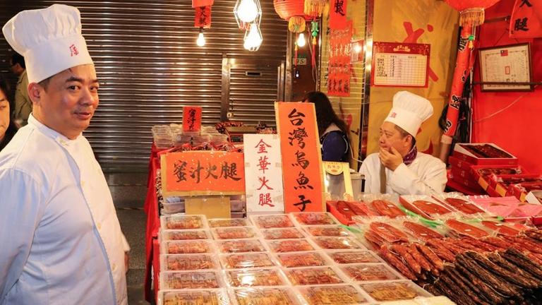 Ein Koch präsentiert die Waren auf einem Stand des Nachtmarktes in Taipeh Ein Koch präsentiert die Waren auf einem Stand des Nachtmarktes in Taipeh