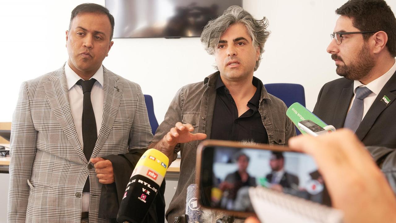 Die Nebenkläger (l-r) Khubaib-Ali Mohammed, Feras Fayyad und Mohammad Alshaar nach dem Ende des heutigen Prozesstages im Koblenzer Gerichtsgebäude mit Journalisten beim ersten Prozess auf deutschem Boden gegen Verbrechen an Syrern in Syrien Die Nebenkläger (l-r) Khubaib-Ali Mohammed, Feras Fayyad und Mohammad Alshaar nach dem Ende des heutigen Prozesstages im Koblenzer Gerichtsgebäude mit Journalisten beim ersten Prozess auf deutschem Boden gegen Verbrechen an Syrern in Syrien