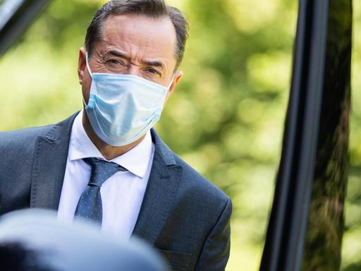 Der Schauspieler Jan Josef Liefers, Schauspieler kommt mit Mundschutz zu den Dreharbeiten zum neuen "Tatort" aus Münster. Der trägt einen dunklen Anzug, weißes Hemd und Krawatte.