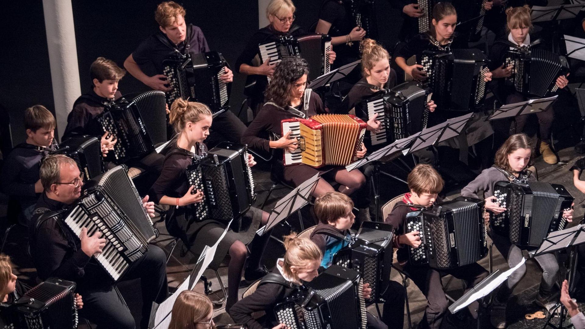 Ein Blick von oben auf ein Akkordeon-Orchester aus Kindern, Jugendlichen und Erwachsenen Ein Blick von oben auf ein Akkordeon-Orchester aus Kindern, Jugendlichen und Erwachsenen