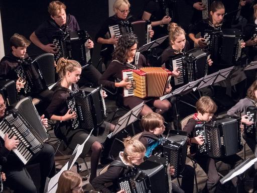 Ein Blick von oben auf ein Akkordeon-Orchester aus Kindern, Jugendlichen und Erwachsenen