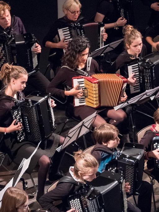 Ein Blick von oben auf ein Akkordeon-Orchester aus Kindern, Jugendlichen und Erwachsenen