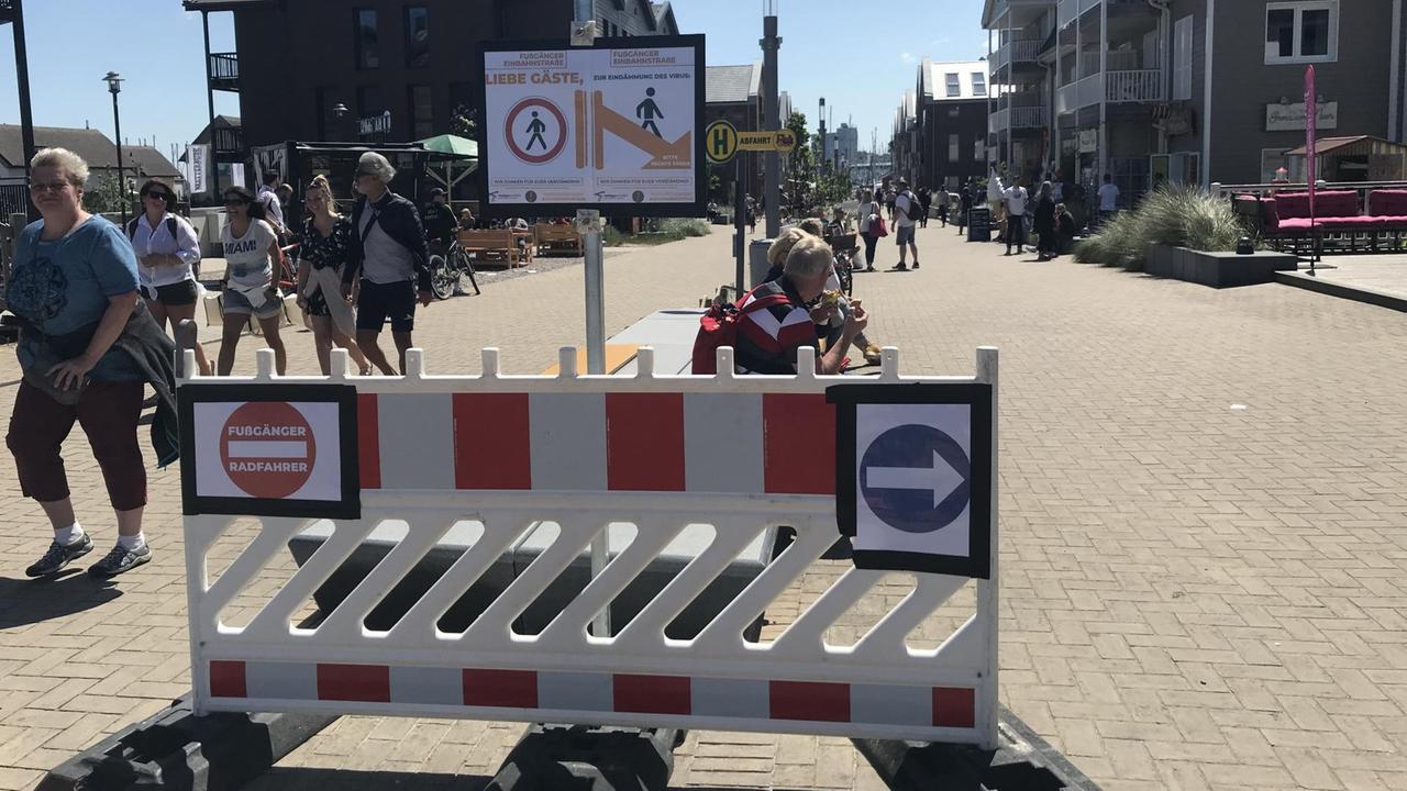 Fußgänger in Heiligenhafen: Ein Schild sorgt dafür, dass die rechte Seite der Fußgängerpassage in die eine Richtung, die linke Seite in die andere Richtung begangen wird. Fußgänger in Heiligenhafen: Ein Schild sorgt dafür, dass die rechte Seite der Fußgängerpassage in die eine Richtung, die linke Seite in die andere Richtung begangen wird.