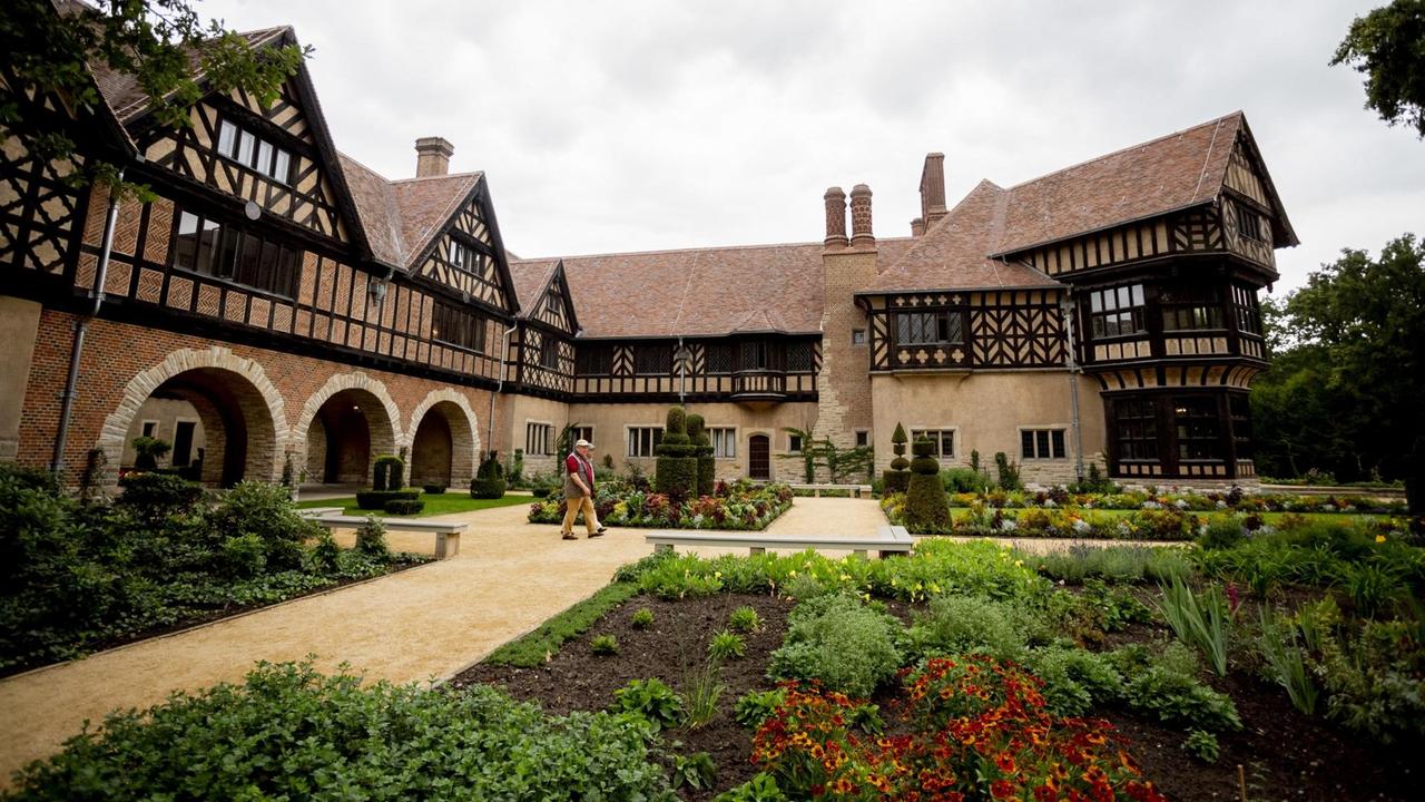 Besucher laufen durch den Prinzengarten des sanierten Schlosses Cecilienhof Besucher laufen durch den Prinzengarten des sanierten Schlosses Cecilienhof