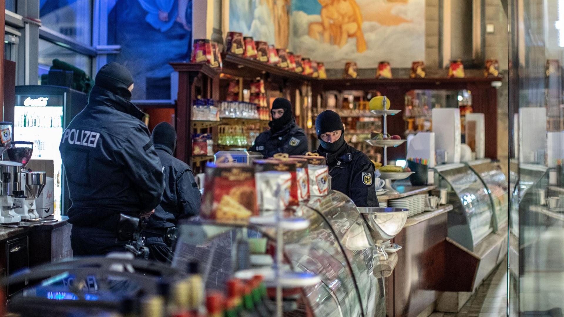 Polizisten stehen bei einer Razzia gegen die Mafia in einem Eiscafé in der Duisburger Innenstadt. Polizisten stehen bei einer Razzia gegen die Mafia in einem Eiscafé in der Duisburger Innenstadt.