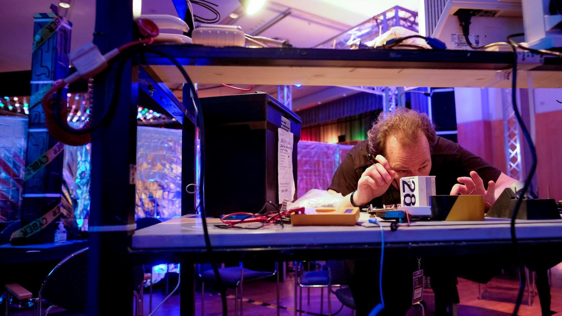 Ein Kongressbesucher arbeitet am 27.12.2016 in Hamburg beim Chaos Communication Congress (CCC) mit einem Lötkolben an einem Computerbauteil.