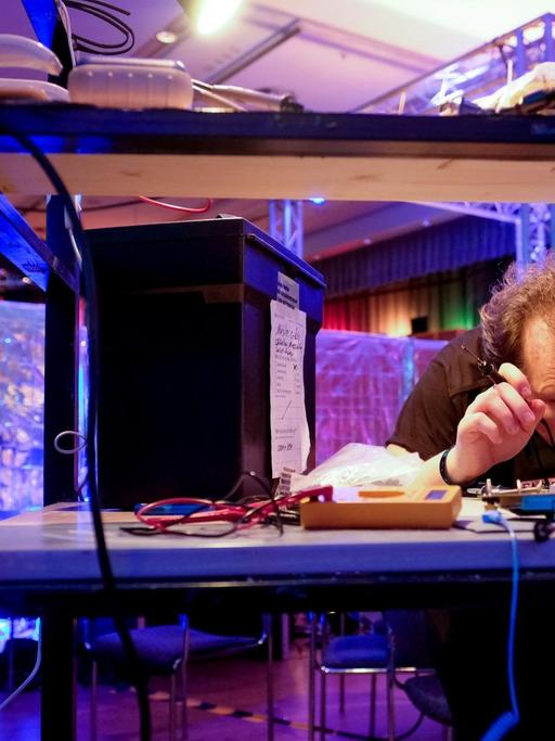 Ein Kongressbesucher arbeitet am 27.12.2016 in Hamburg beim Chaos Communication Congress (CCC) mit einem Lötkolben an einem Computerbauteil.