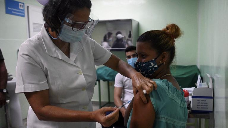 Eine Krankenpflegerin sitzt auf einem Stuhl und bekommt die zweite Dosis des kubanischen Impfstoffkandidaten Abdala verabreicht.