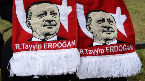 Sie sehen einen Schal mit dem Konterfei des türkischen Präsidenten - hier hochgehalten in Berlin.