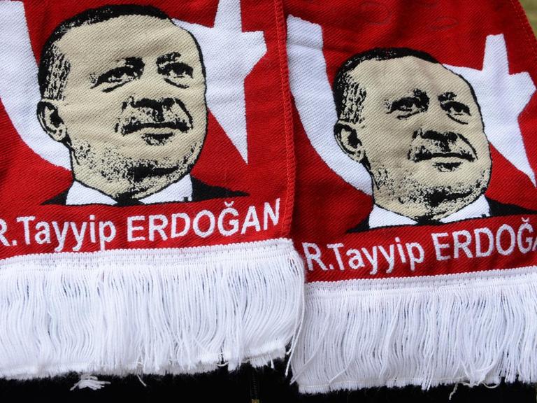 Sie sehen einen Schal mit dem Konterfei des türkischen Präsidenten - hier hochgehalten in Berlin.