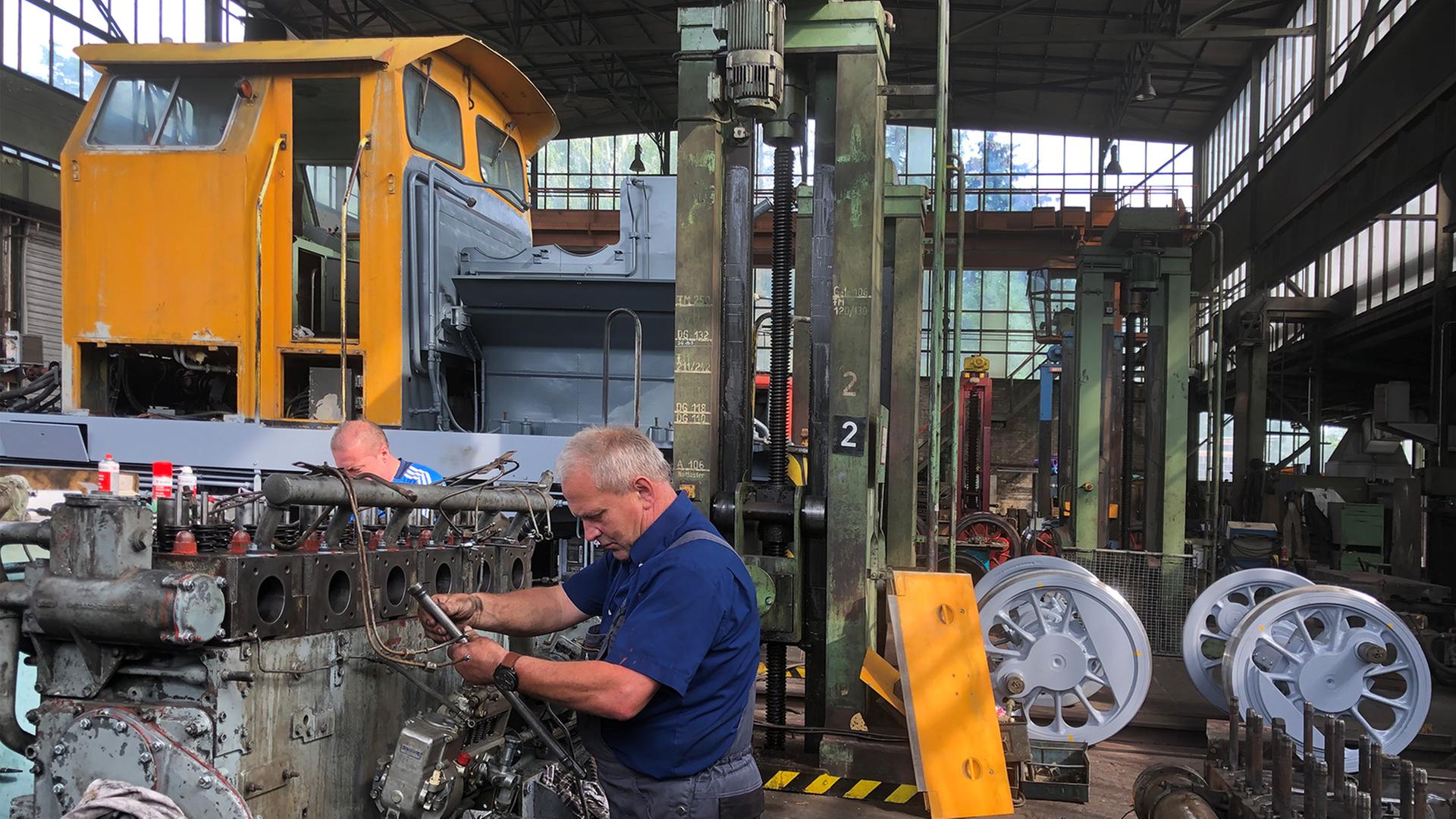 Arbeiter in Overalls in der Werkhalle in Benndorf. Arbeiter in Overalls in der Werkhalle in Benndorf.