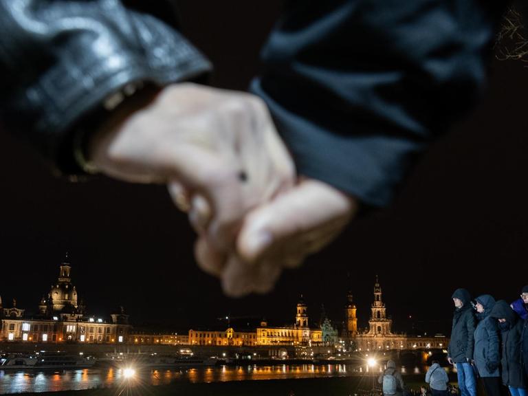 Teilnehmer der Menschenkette in Dresden halten sich an den Händen.