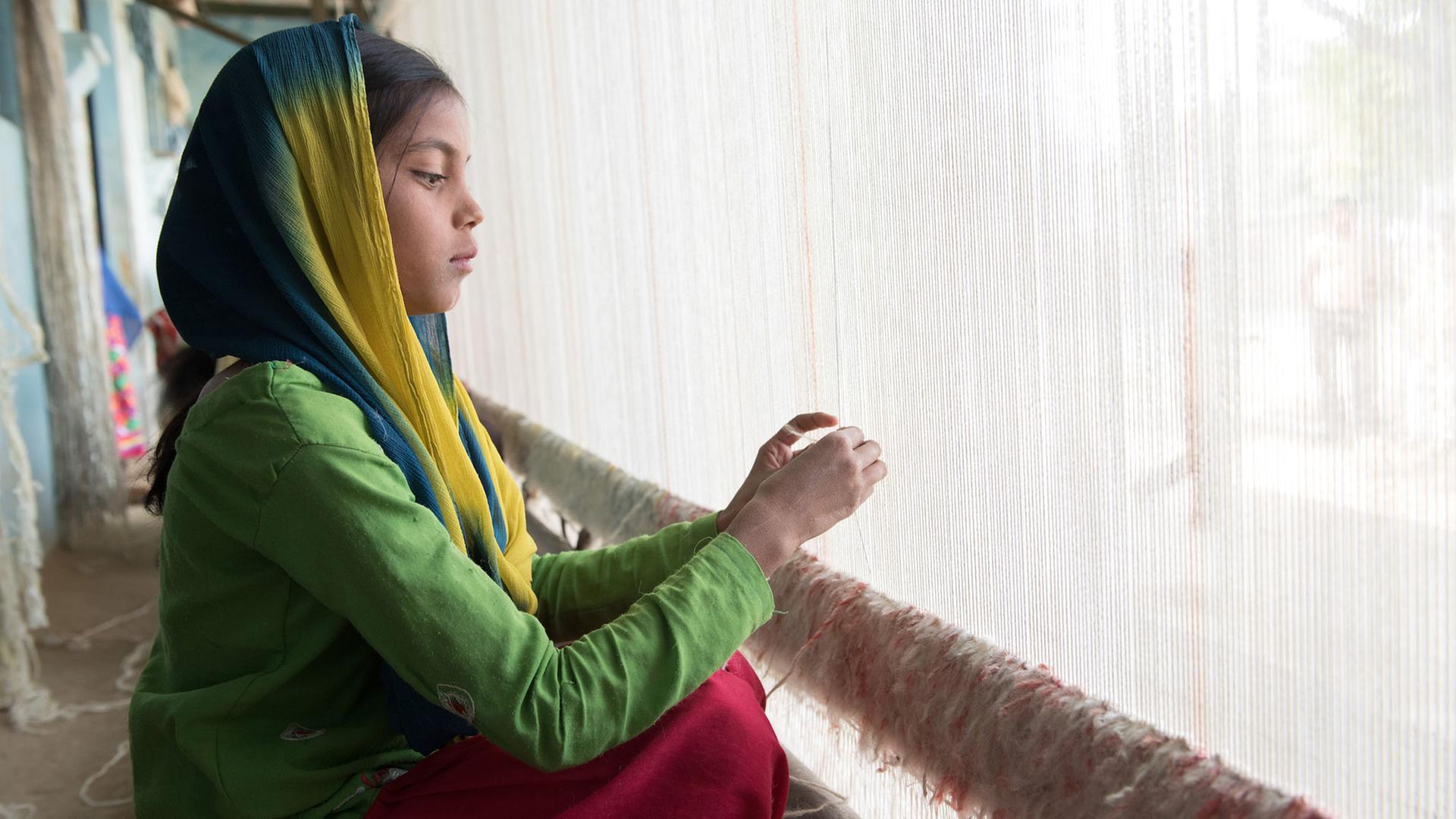 Das Bild zeigt am linken Bildrand ein Mädchen aus Indien, in grünem Gewand, bei ihrer täglichen Arbeit am Webrahmen. Dieses Foto ist das Motiv des aktuellen Plakats der Aktion Dreikönigssingen 2018. Das Bild zeigt am linken Bildrand ein Mädchen aus Indien, in grünem Gewand, bei ihrer täglichen Arbeit am Webrahmen. Dieses Foto ist das Motiv des aktuellen Plakats der Aktion Dreikönigssingen 2018.