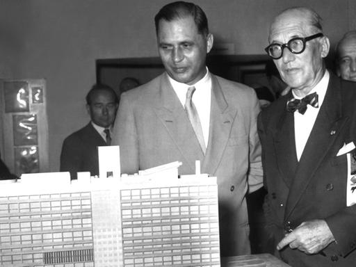 Der französisch-schweizerische Architekt und Städteplaner Le Corbusier (r.) und der Berliner Bausenator Rolf Schwedler betrachten während der Ausstellungseröffnung am 7.9.1957 im ehemaligen British Center am Kurfürstendamm das Modell von Corbusiers "Strahlender Stadt" (Berlin).