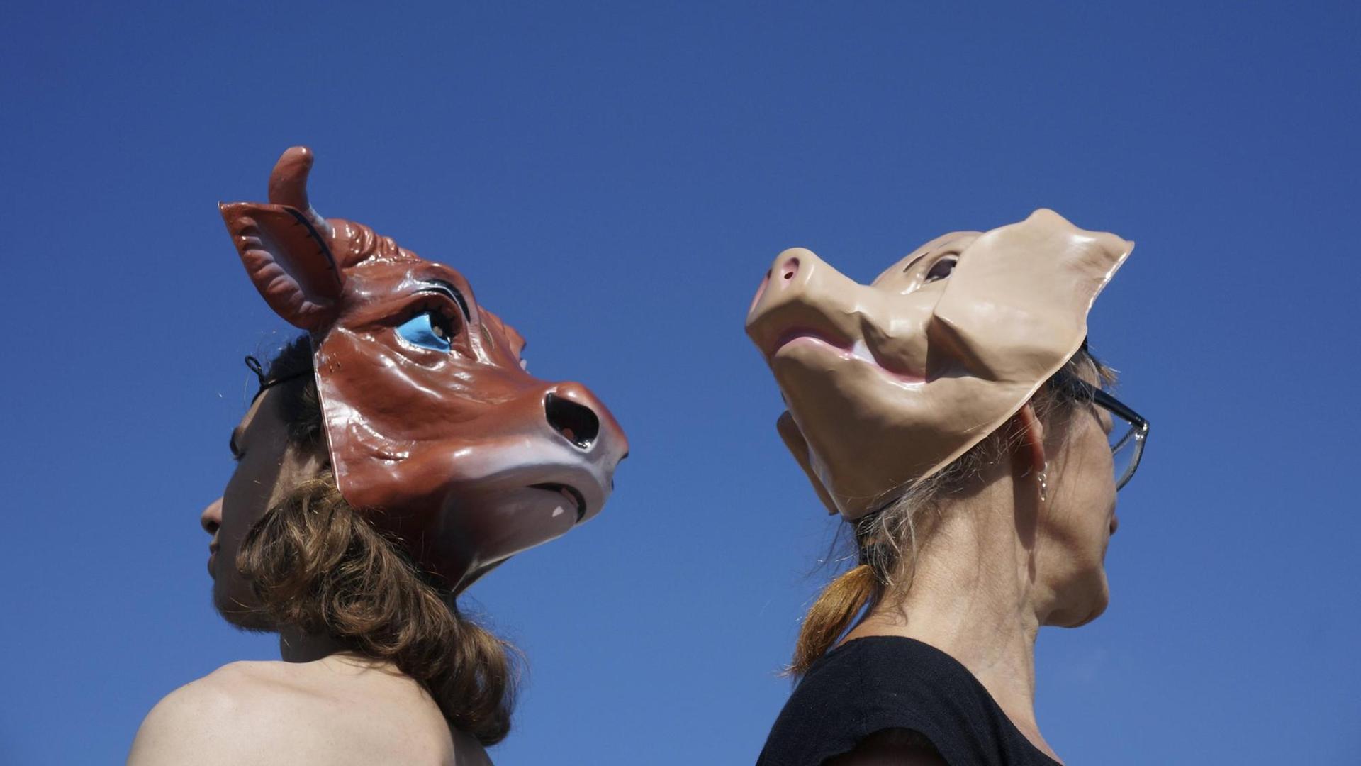 Teilnehmer der Veganer-Demonstration tragen am Hinterkopf Tiermasken.